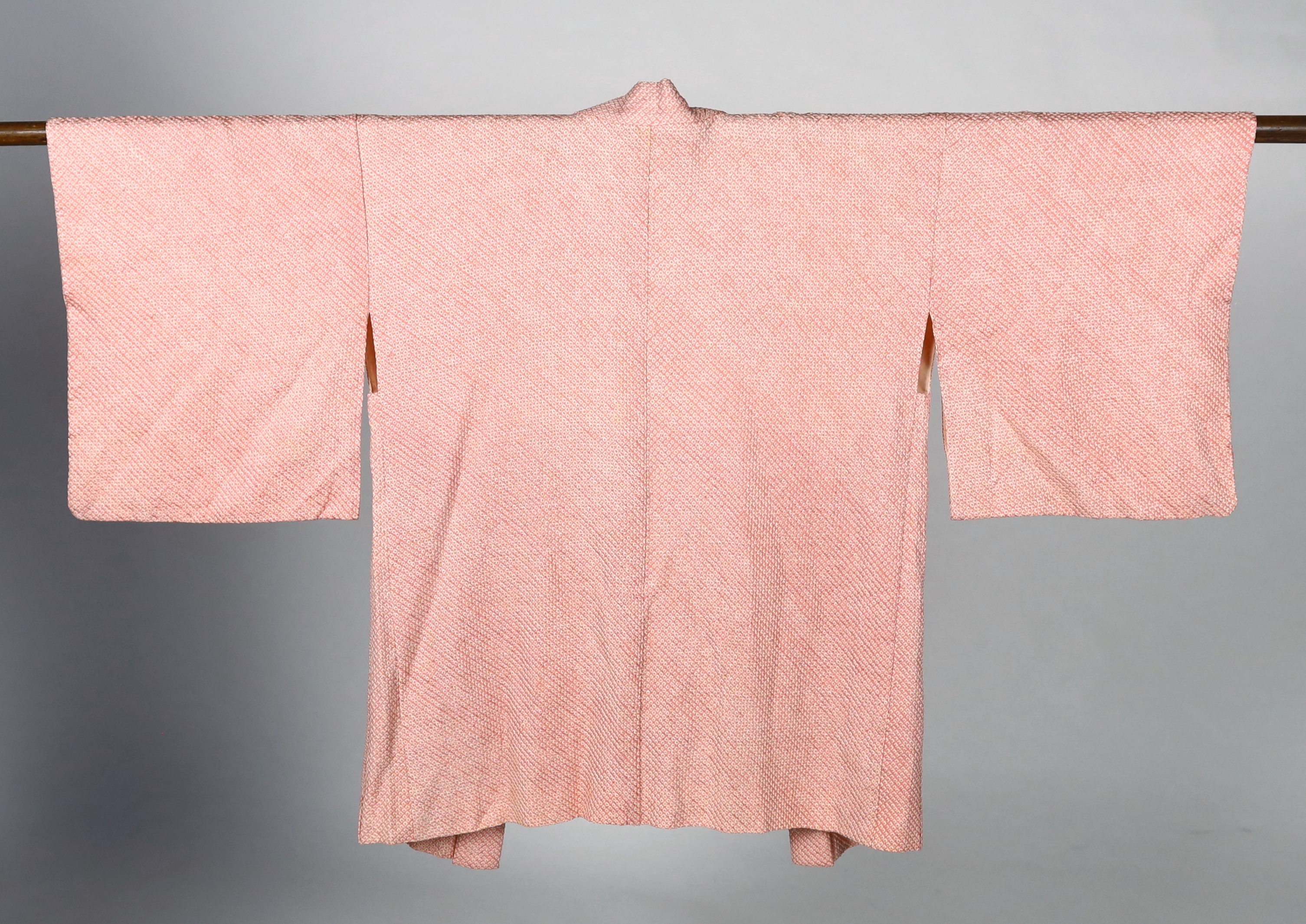 A Japanese Shibori kimono, the silk minutely tie-dyed into a raised spot like design by hand, circa 1920's. This design 'haori himo', lined with a silk damask, 69cm long